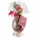 Handcrafted dark Easter egg with chopped hazelnuts